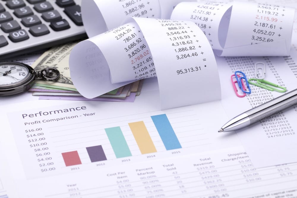 A performance report with a colourful bar chart, rolled receipts, a pen and a calculator — illustration for investment taxation
