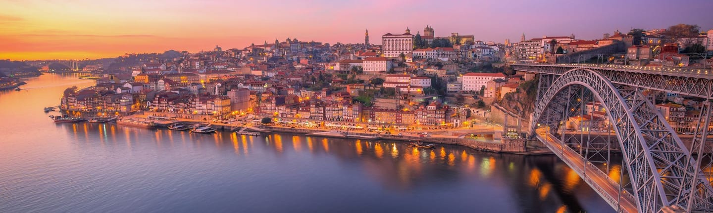 Panorama of Porto on the Douro river at sunset — the Dom Luís I bridge and the old town