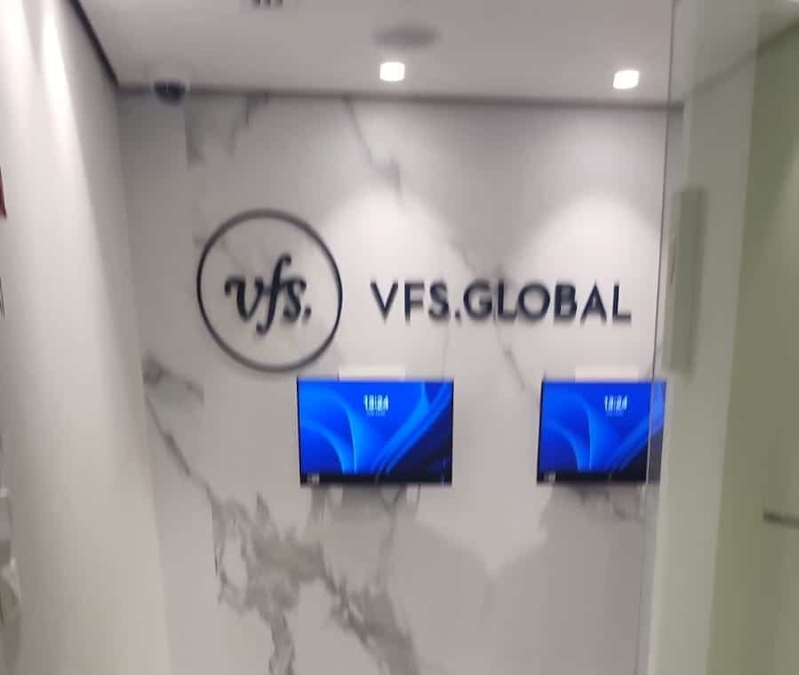 Entrance to the VFS Global offices — the logo on a light marble wall and two screens