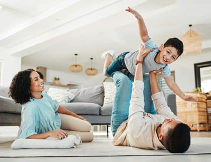 Portrait, mother or child playing with father on floor relaxing as a happy family bonding in Portug